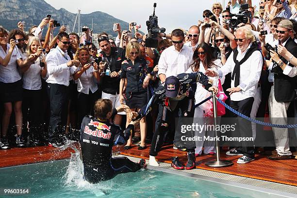 Sebastian Vettel of Germany and Red Bull Racing tries to pull race winner Mark Webber of Australia and Red Bull Racing into the Red Bull Energy...