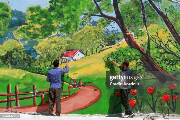 Two painters paint a picture on a wall on the purpose of the reflecting Van's natural beauties in Van, Turkey on July 11, 2018. Van's Baskale...