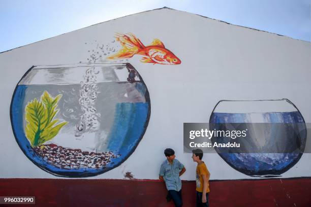 Children are seen in front of a painted wall which painted by painters on the purpose of the reflecting Van's natural beauties in Van, Turkey on July...