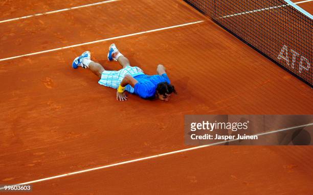 Rafael Nadal of Spain lays on court celebrating match point over Roger Federer of Switzerland in their final match during the Mutua Madrilena Madrid...