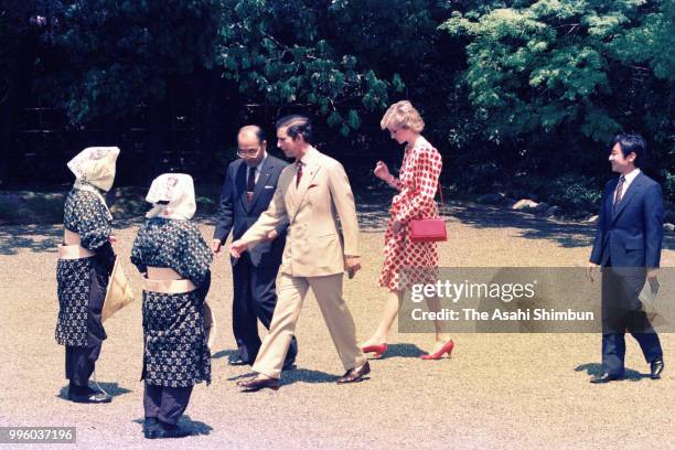 Prince Charles, Prince of Wales, Princess Diana, Princess of Wales and Prince Naruhito talk with female gardeners wearing traditional Oharame...