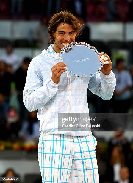 Rafael Nadal of Spain bites his winners trophy after his straight sets victory against Roger Federer of Switzerland in the mens final match during...