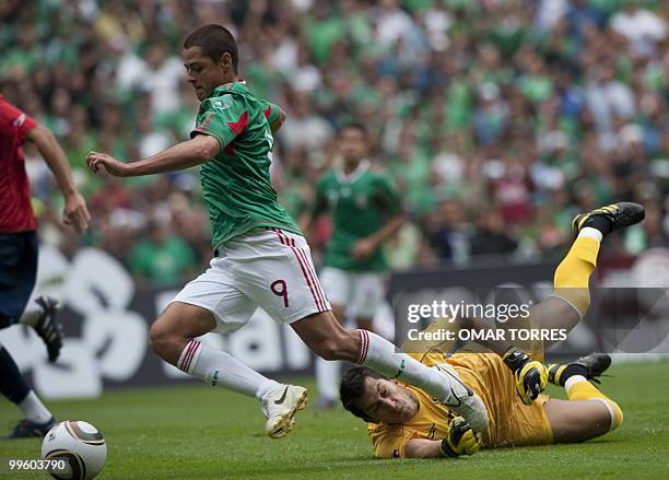 Javier Hernandez of Mexico vies for the ball with goalkeeper Luis Marin of Chile during their friendly footbal match before their departure for South...