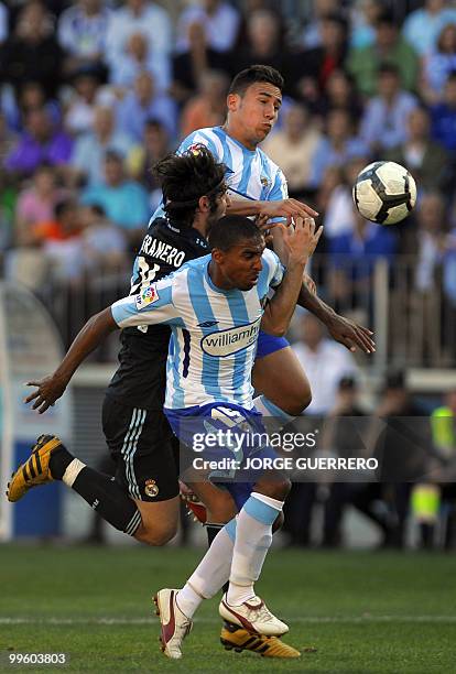 Real Madrid's midfielder Esteban Granero vies for the ball with Malaga's Danish defender Patrick Jan Mtiliga and Ivan Gonzalez during a Spanish...