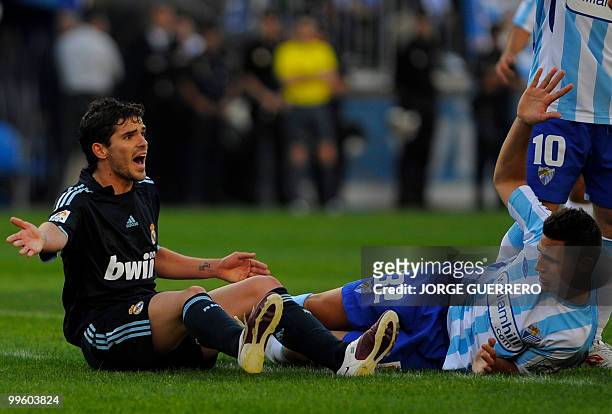 Real Madrid's Argentinian midfielder Fernando Gago and Malaga's Ivan Gonzalez react during a Spanish league football match at Rosaleda stadium on May...