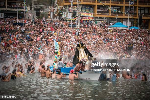 Statue of San Telmo is sailed around the habour during the procession of the Virgen del Carmen, the patron saint of fishermen, at the Puerto de la...