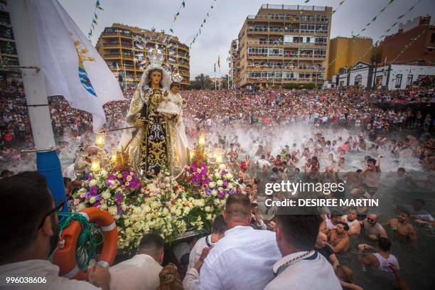 Carriers of the Great God Power brotherhood unload Virgin del Carmen statue after its journey at the Puerto de la Cruz on the Spanish Canary island...