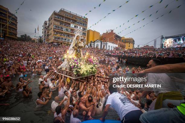 Carriers of the Great God Power brotherhood unload Virgin del Carmen statue after its journey at the Puerto de la Cruz on the Spanish Canary island...