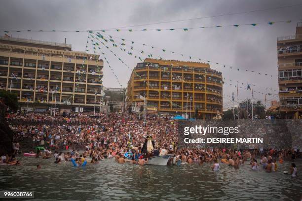 Statue of San Telmo is sailed around the habour during the procession of the Virgen del Carmen, the patron saint of fishermen, at the Puerto de la...