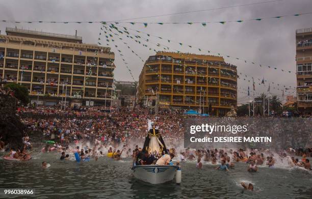 Statue of San Telmo is sailed around the habour during the procession of the Virgen del Carmen, the patron saint of fishermen, at the Puerto de la...