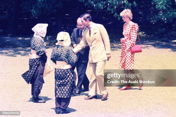 Prince Charles, Prince of Wales and Princess Diana, Princess of Wales talk with female gardeners wearing traditional Oharame costumes at the...