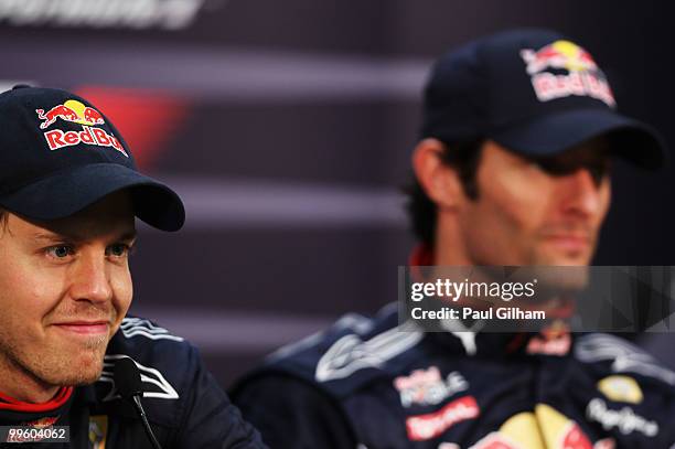 Sebastian Vettel of Germany and Red Bull Racing is seen team mate Mark Webber of Australia and Red Bull Racing at the drivers post race press...