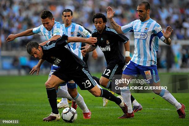 Real Madrid's Dutch midfielder Rafael van der Vaart vies for the ball with Malaga's Ivan Gonzalez and Jesus Gamez during a Spanish league football...