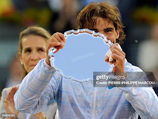 Spain's Rafael Nadal celebrates with his trophy after winning against Roger Federer during their final match of the Madrid Masters on May 16, 2010 at...