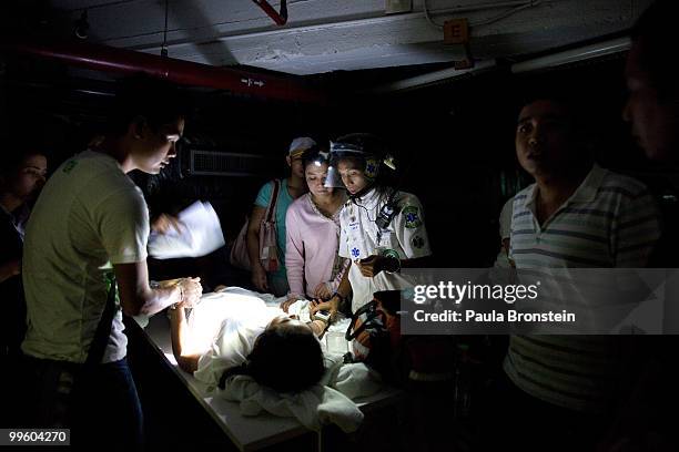 Emergency medical personnel work on a patience at the Dusit Thani hotel after an attack by red shirts as the violence in central Bangkok continues on...