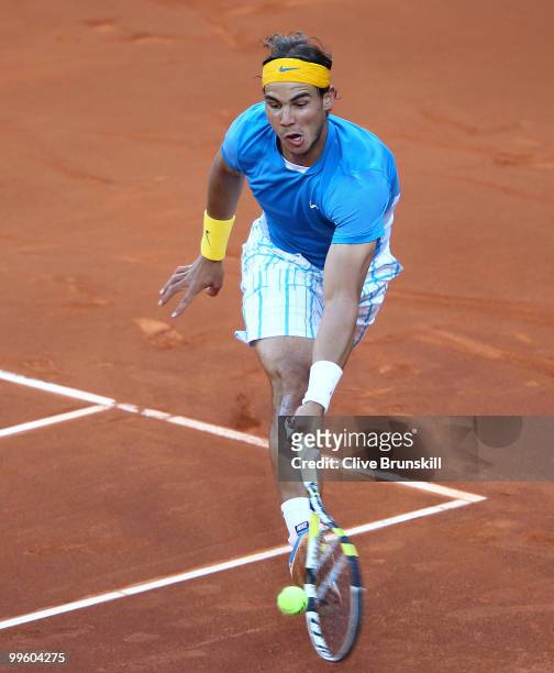Rafael Nadal of Spain stretches to play a forehand against Roger Federer of Switzerland in the mens final match during the Mutua Madrilena Madrid...