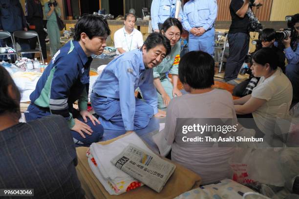 Japanese Prime Minister Shinzo Abe talks with evacuees at a gymnasium of the Okada Elementary School where people take shelter after the are was...