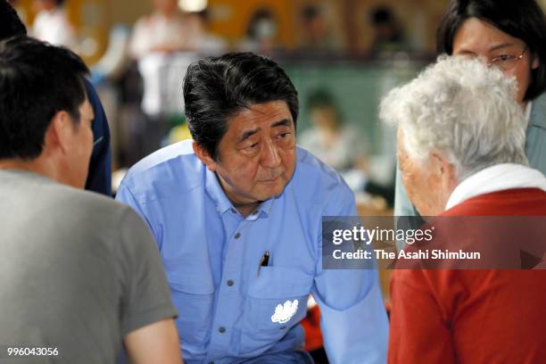 Japanese Prime Minister Shinzo Abe talks with evacuees at a gymnasium of the Okada Elementary School where people take shelter after the are was...