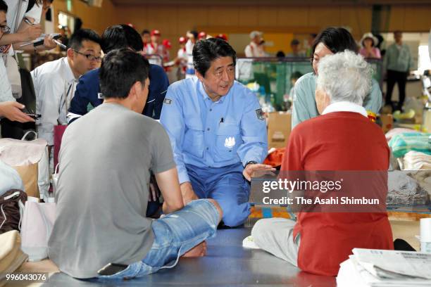 Japanese Prime Minister Shinzo Abe talks with evacuees at a gymnasium of the Okada Elementary School where people take shelter after the are was...