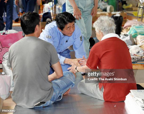 Japanese Prime Minister Shinzo Abe talks with evacuees at a gymnasium of the Okada Elementary School where people take shelter after the are was...