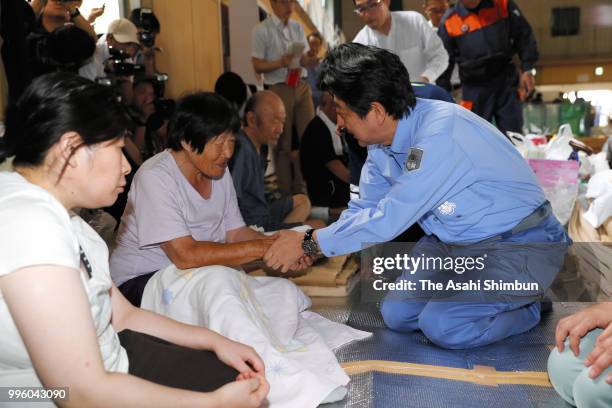 Japanese Prime Minister Shinzo Abe talks with evacuees at a gymnasium of the Okada Elementary School where people take shelter after the are was...