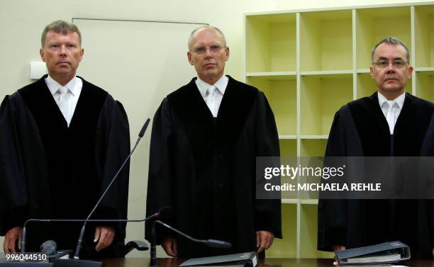 Judges Peter Lang, Manfred Goetzl and Konstantin Kuchenbauer stand in a courtroom before the proclamation of sentence in the trial against Beate...