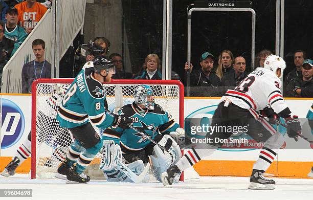 Dustin Byfuglien of the Chicago Blackhawks and Evgeni Nabokov and Joe Pavelski of the San Jose Sharks watch the puck in Game One of the Western...