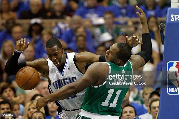 Dwight Howard of the Orlando Magic loses the ball as he is defended by Glen Davis of the Boston Celtics in the first quarter of Game One of the...