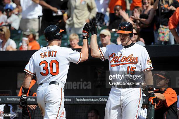 Luke Scott of the Baltimore Orioles is congratulated by Craig Tatum after hitting a home run in the ninth inning against the Cleveland Indians at...