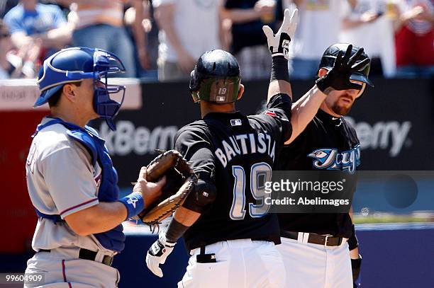 Jose Bautista and John Buck of the Toronto Blue Jays celebrate Jose Bautista home run against the Texas Rangers during a MLB game at the Rogers...