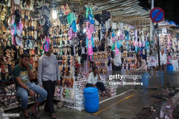 Vendors wait for customers at footwear stalls in the suburb of Bandra in Mumbai, India, on Tuesday, July 10, 2018. The monsoon is the lifeline of...