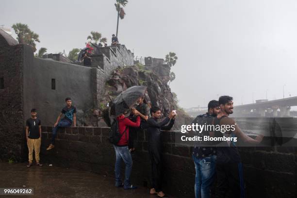 People stand in the rain at Bandra Fort in the suburb of Bandra in Mumbai, India, on Tuesday, July 10, 2018. The monsoon is the lifeline of Asia's...