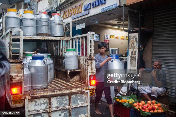 Worker loads a truck with milk cans in the suburb of Bandra in Mumbai, India, on Tuesday, July 10, 2018. The monsoon is the lifeline of Asia's...