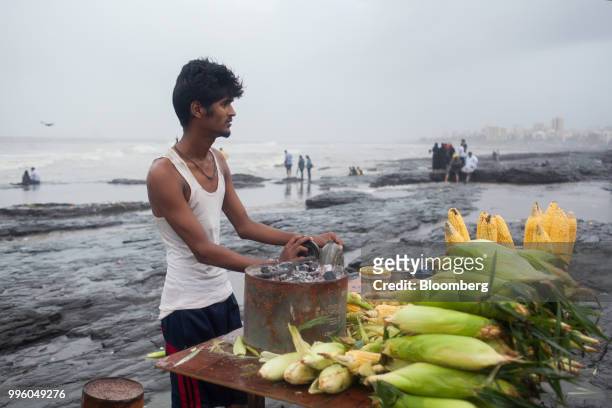 Vendor selling corn waits for customers at the shoreline in the suburb of Bandra in Mumbai, India, on Tuesday, July 10, 2018. The monsoon is the...