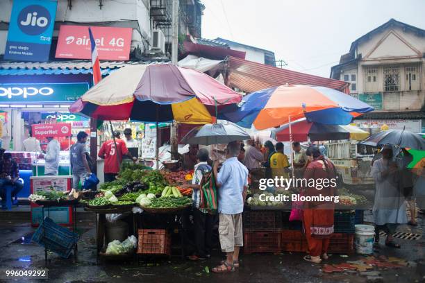 Customers buy vegetables from street stalls in the suburb of Bandra in Mumbai, India, on Tuesday, July 10, 2018. The monsoon is the lifeline of...