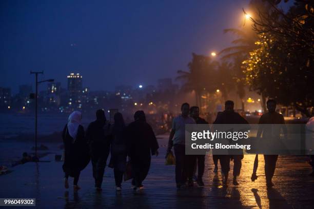 Visitors walk along the promenade at night in the suburb of Bandra in Mumbai, India, on Tuesday, July 10, 2018. The monsoon is the lifeline of Asia's...