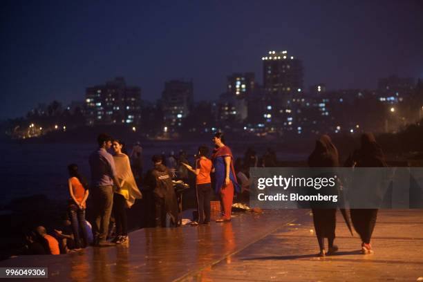 Visitors gather along the promenade at night in the suburb of Bandra in Mumbai, India, on Tuesday, July 10, 2018. The monsoon is the lifeline of...