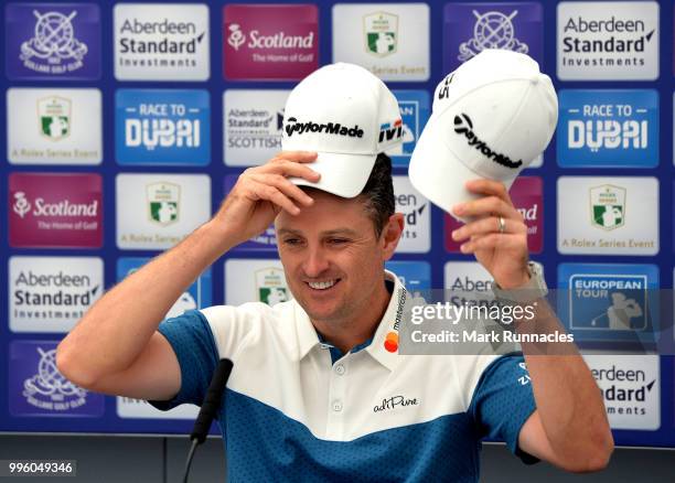 Justin Rose of England changes hats as he speaks to the media during previews for the Aberdeen Standard Investments Scottish Open at Gullane Golf...