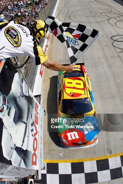 Kyle Busch, driver of the M&M's Toyota, crosses the finish line to win the NASCAR Sprint Cup Series Autism Speaks 400 at Dover International Speedway...