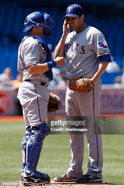 Colby Lewis and Matt Treanor of the Texas Rangers talk during a MLB game against of the Toronto Blue Jays at the Rogers Centre May 16, 2010 in...