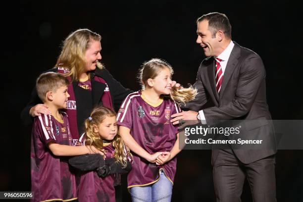 Cameron Smith hugs his family as he appears on stage during a "We love Queenslanders" Captain's Tributeduring game three of the State of Origin...