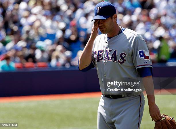 Colby Lewis of the Texas Rangers walks to the dug-out while playing against the Toronto Blue Jays during a MLB game at the Rogers Centre May 16, 2010...