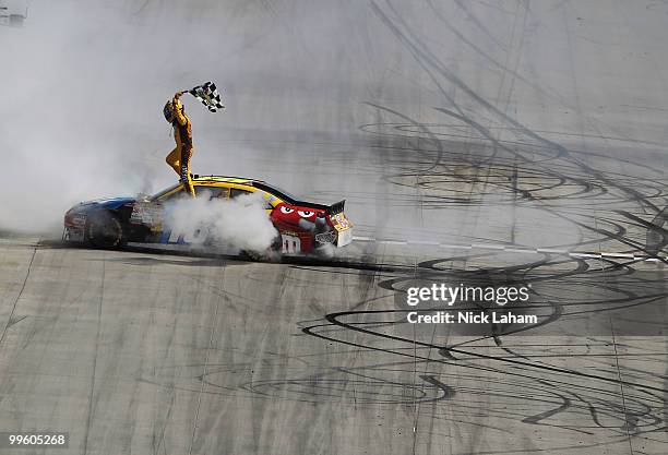 Kyle Busch, driver of the M&M's Toyota, celebrates with the checkered flag after winning the NASCAR Sprint Cup Series Autism Speaks 400 at Dover...