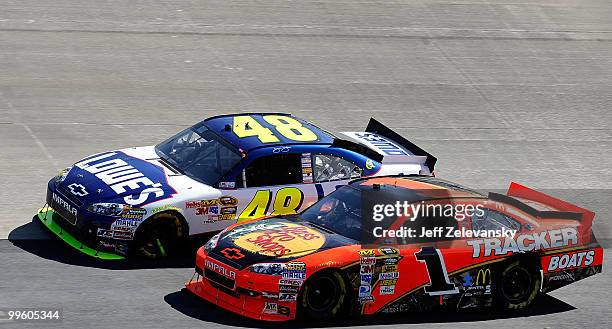 Jimmie Johnson, driver of the Lowe's Chevrolet, tries to get onto pit road around Jamie McMurray, driver of the Bass Pro Shops Chevrolet, on the...