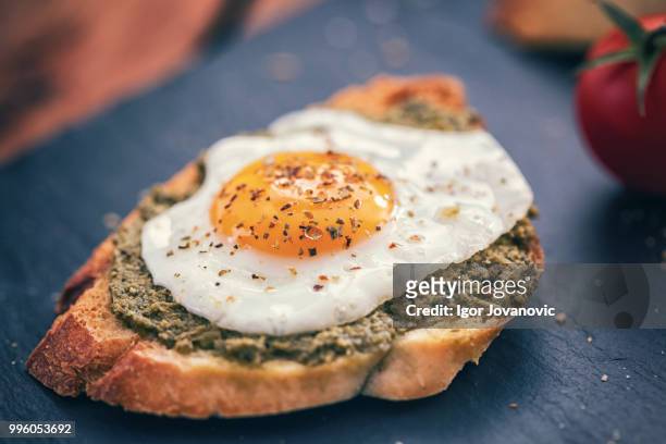 poached egg and pesto sauce on toast - pesto stock pictures, royalty-free photos & images