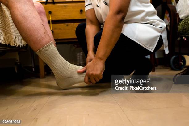 女護士中鏡頭仔細按摩老人的腳在退休回家 - outpatient care 個照片及圖片檔