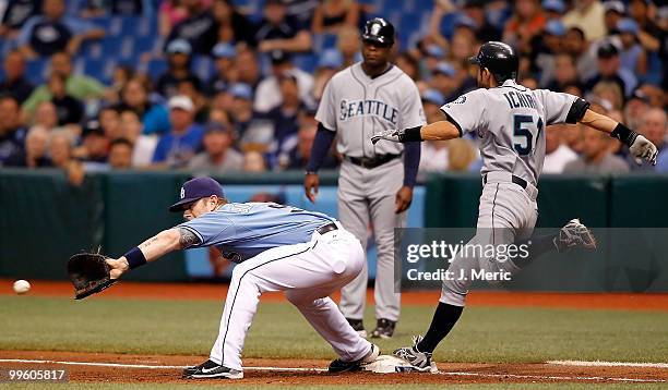Outfielder Ichiro Suzuki of the Seattle Mariners beats the throw to first as first baseman Hank Blalock of the Tampa Bay Rays takes the throw during...