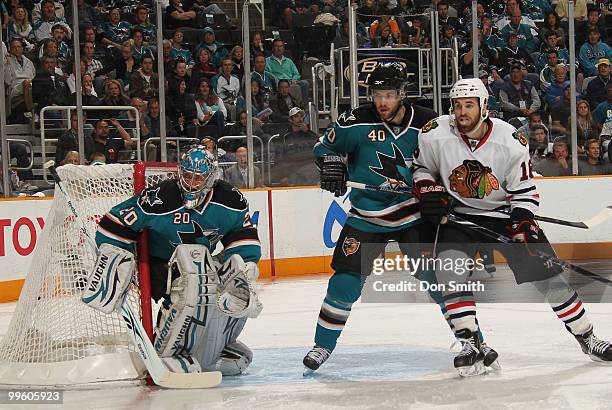 Andrew Ladd of the Chicago Blackhawks battles for position with Kent Huskins and Evgeni Nabokov of the San Jose Sharks in Game One of the Western...