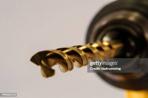 shiny gold drill bit in drill - drill bit stockfoto's en -beelden
