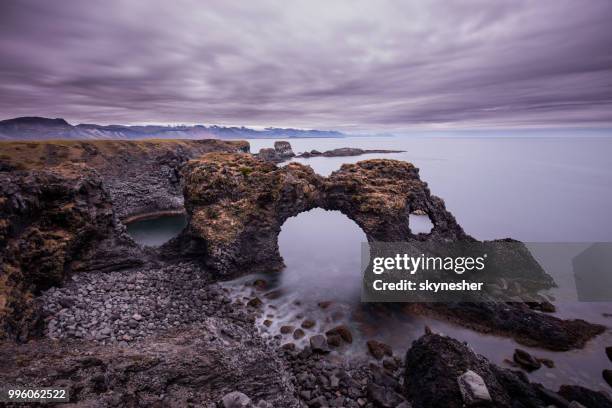 boog rock en kustlijn op arnarstapi, ijsland. - arnarstapi stockfoto's en -beelden